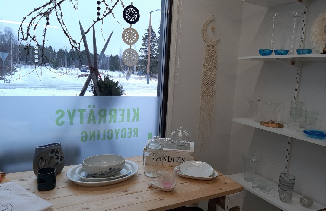 Kierrätysmyymälässä kaikki tiptop. Ikkunateippaukset kertovat palveluista.